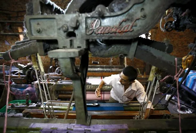 A man works on a machine to make a shawl inside a textile factory in Lalitpur, Nepal August 21, 2015. (Photo by Navesh Chitrakar/Reuters)