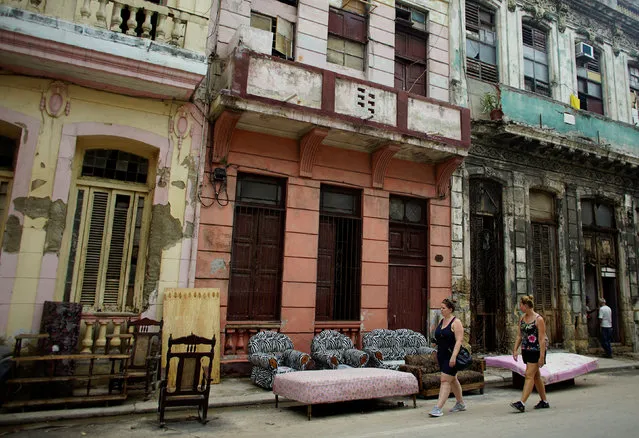 Tourists walk past furniture let to dry on the street after Hurricane Irma caused flooding and a blackout, in Havana, Cuba September 11, 2017. (Photo by Alexandre Meneghini/Reuters)