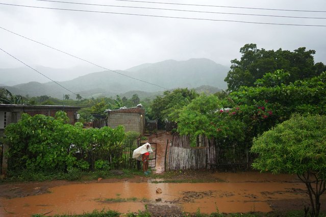 A woman stands in front of her home ahead of Hurricane Melissa's landfall in Caleta Blanca, Cuba, on October 28, 2025. (Photo by Alexandre Meneghini/Reuters)