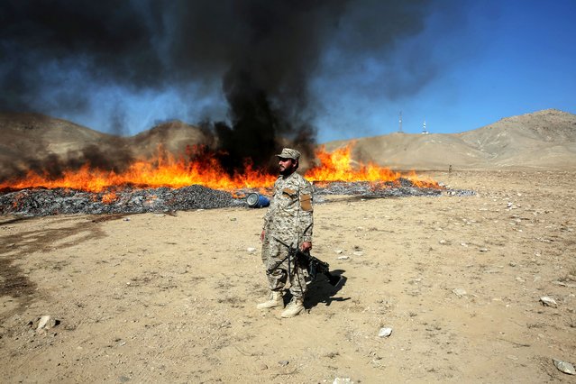 Afghan security officials stand guard as seized narcotics are burned in Kabul, Afghanistan, 09 November 2025. Afghanistan's Ministry of Interior said 200,000 kilograms of drugs were destroyed in the Deh Sabz district, following the Islamic Emirate's ban on drug production and trafficking. (Photo by Samiullah Popal/EPA)