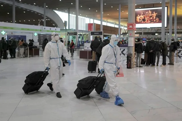 Passengers from Taiwan wearing protective gear arrive to board their plane at Paris Charles de Gaulle Airport in Roissy , north of Paris, Monday, February 1, 2021. France says it's closing its borders to people arriving from outside the European Union starting Sunday to try to stop the growing spread of new variants of the virus and avoid a third lockdown. (Photo by Francois Mori/AP Photo)