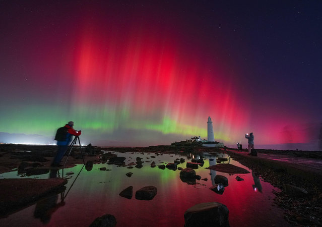 The aurora borealis, also known as the northern lights, glow in the sky over St Mary's Lighthouse in Whitley Bay on the North East coast, England, Wednesday November 12, 2025. (Photo by  Owen Humphreys/PA via AP Photo)