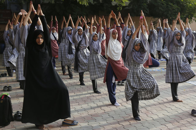 Indian Muslim students practice yoga ahead of International Yoga Day at a school in Ahmadabad, India, Wednesday, June 20, 2018. International Yoga Day will be celebrated on June 21. (Photo by Ajit Solanki/AP Photo)