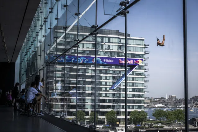 In this handout image provided by Red Bull, Catalin Preda of Romania dives from the 27.5 metre platform during the first competition day of the first stop of the Red Bull Cliff Diving World Series on June 02, 2023 in Boston, Massachusetts. (Photo by Romina Amato/Red Bull via Getty Images)