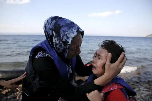 An Afghan mother comforts her crying child moments after a dinghy carrying Afghan migrants arrived on the island of Lesbos, Greece August 23, 2015. (Photo by Alkis Konstantinidis/Reuters)