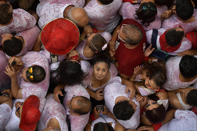 Revellers pack the main square during the launch of the “Chupinazo” rocket, to celebrate the official opening of the 2018 San Fermin fiestas with daily bull runs, bullfights, music and dancing in Pamplona, Spain, Friday July 6, 2018. (Photo by Alvaro Barrientos/AP Photo)