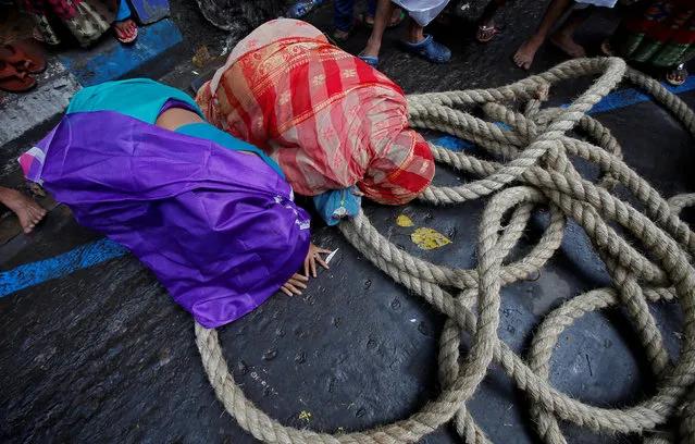 Hindu women lie on a road as they touch a holy rope tied to a “Rath”, or the chariot of Lord Jagannath, to seek blessings during the annual Rath Yatra, or chariot procession, in Kolkata, India July 14, 2018. (Photo by Rupak De Chowdhuri/Reuters)