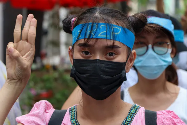 An anti-coup protester flashes the three-fingered salute while wearing a headband that reads R2P, which means Responsibility to Protect, during a gathering in Ahlone township in Yangon, Myanmar Monday, April 12, 2021. The protesters have called for foreign intervention to aid them under the doctrine of Responsibility to Protect, or R2P, devised to deal with matters such as genocide, war crimes, ethnic cleansing and crimes against humanity. (Photo by AP Photo/Stringer)