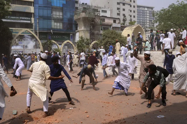 Two factions of protestors clash after Friday prayers at Baitul Mokarram mosque in Dhaka, Bangladesh, Friday, March 26, 2021. Witnesses said violent clashes broke out after one faction of protesters began waving their shoes as a sign of disrespect to Indian Prime Minister Narendra Modi, and another group tried to stop them. Local media said the protesters who tried to stop the shoe-waving are aligned with the ruling Awami League party. The party criticized the other protest faction for attempting to create chaos in the country during Modi’s visit. (Photo by Mahmud Hossain Opu/AP Photo)