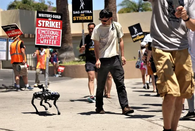 A robot dog named Gato moves with a sign on it as SAG-AFTRA actors and Writers Guild of America (WGA) writers walk the picket line during their ongoing strike outside Paramount Studios in Los Angeles, California, U.S., August 2, 2023. (Photo by Mario Anzuoni/Reuters)