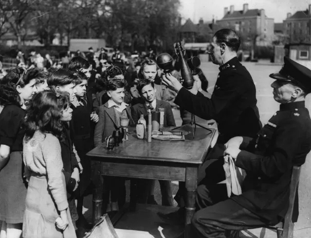 Children in Hackney are advised on road safety and the dangers of picking up strange objects by police officers, 16th April 1943. (Photo by Fox Photos/Getty Images)