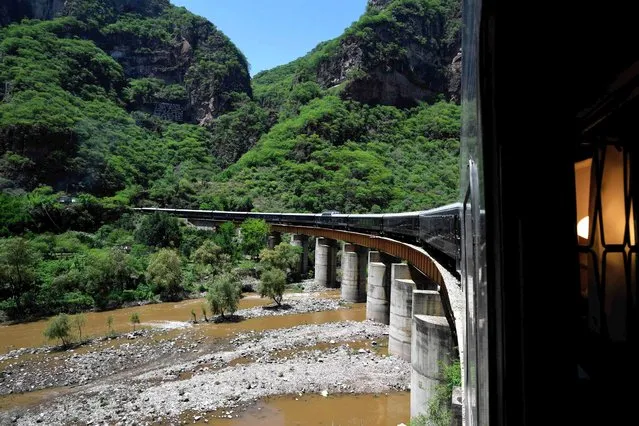 View of the “Chepe Express” train in Temoris, Chihuahua sate, Mexico on July 17, 2023. From the heartland of a notorious drug cartel to rugged mountains home to remote Indigenous communities, Mexico's “El Chepe” train takes adventure-seeking travelers on a spectacular journey through the Copper Canyon. (Photo by Claudio Cruz/AFP Photo)