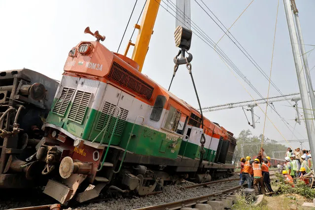 Rescuers move a damaged engine of a passenger train after it derailed in Harchandpur, in Uttar Pradesh, October 10, 2018. (Photo by Pawan Kumar/Reuters)