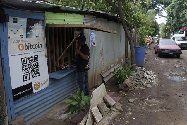 Santos Hilario Galvez, a Salvadoran who works as a builder at the Hope House, an organization that sponsors the use of cryptocurrencies in El Zonte beach, makes a purchase at a small store that accepts Bitcoin, in Tamanique, El Salvador, Wednesday, June 9, 2021. El Salvador's Legislative Assembly has approved legislation making the cryptocurrency Bitcoin legal tender in the country, the first nation to do so, just days after President Nayib Bukele made the proposal at a Bitcoin conference. (Photo by Salvador Melendez/AP Photo)