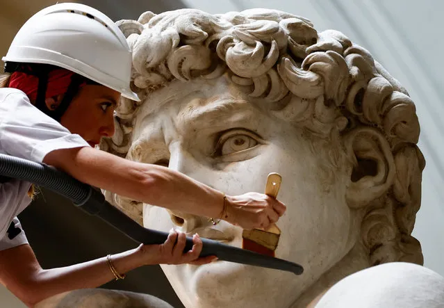 Restorer Eleonora Pucci cleans dust and debris off Michelangelo's statue of David using a backpack vacuum and synthetic fibre brush at the Galleria dell'Accademia, in Florence, Italy on September 25, 2023. (Photo by Yara Nardi/Reuters)