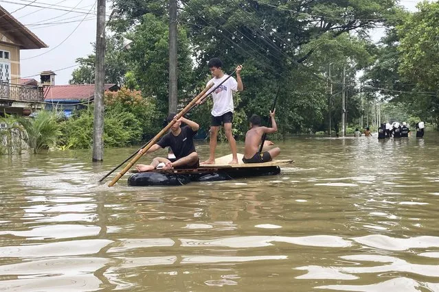 Local residents ride a raft made with inner-tubes along a flooded road in Bago, Myanmar, about 80 kilometers (50 miles) northeast of Yangon, Friday, August 11, 2023. (Photo by AP Photo/Stringer)