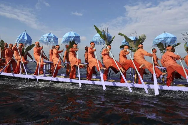 Inntha ethnic people row on a long boat in a procession carrying Buddha images to a monastery during the pagoda festival Thursday, October 19, 2023, in Inlay Lake, southern Shan State, Myanmar. (Photo by Thein Zaw/AP Photo)