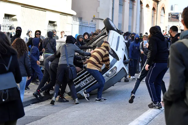 Protesters overturn a vehicle on December 6, 2018 in Marseille, southern France, during a demonstration of high school students protesting against French government Education reforms. (Photo by Gérard Julien/AFP Photo)