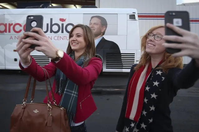 Women take selfies in front of U.S. Republican presidential candidate Marco Rubio's bus following a campaign event in an airport hanger in Greenville, South Carolina, February 12, 2016. (Photo by Carlo Allegri/Reuters)