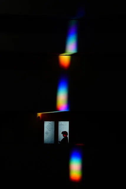 A visitor is silhouetted against a door as a rainbow created by prisms at the Smithsonianb National Museum of the American Indian on Saturday November 18, 2023 in Washington, DC. (Photo by Matt McClain/The Washington Post)