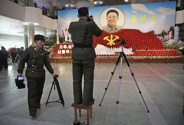 North Korean military soldiers take photos of a portrait of their late leader Kim Jong Il at a flower festival as part of celebrations a day before the birthday anniversary, also known as the “Day of the Shining Star”, of Kim Jong Il on Monday, February 15, 2016, in Pyongyang, North Korea. On Tuesday, Feb. 16, North Korea marks the late leader Kim Jong Il's 74th birthday anniversary. (Photo by Wong Maye-E/AP Photo)