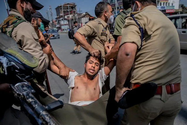 Indian policemen detain a Kashmiri Shiite Muslim for participating in a religious procession in central Srinagar, Indian controlled Kashmir, Tuesday, August 17, 2021. (Photo by Dar Yasin/AP Photo)