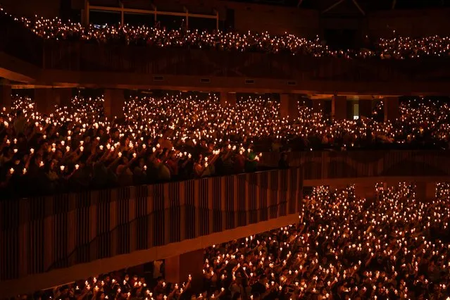 Christian devotees hold candles during a midnight mass on Christmas Eve at the Bethany church in Surabaya on December 24, 2023. (Photo by Juni Kriswanto/AFP Photo)