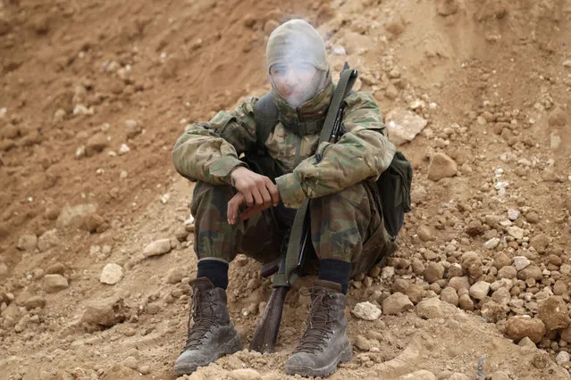 A rebel fighter smokes a cigarette with his weapon on the outskirts of the northern Syrian town of al-Bab, Syria January 26, 2017. (Photo by Khalil Ashawi/Reuters)