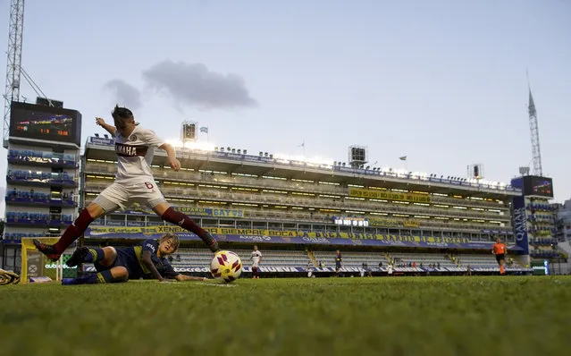 Boca Juniors' Yamila Rodriguez, below, fights for the ball with Lanus's Leila Garcia during the Superliga women's soccer tournament in Buenos Aires, Argentina, Saturday, March 9, 2019. The women competed in one of Argentina's most famous stadiums on Saturday, a milestone for the female players who are fighting for the same rights as male soccer players in the country's most popular sport. (Photo by Natacha Pisarenko/AP Photo)