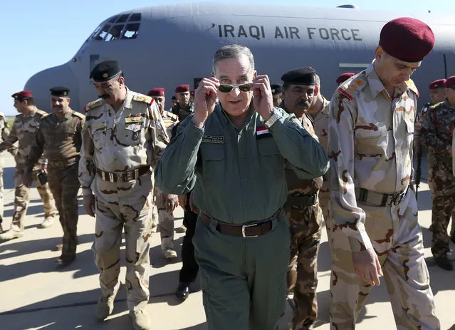 Iraqi Defense Minister Khaled al-Obeidi, center, arrives at a military a base outside Tikrit, 130 kilometers (80 miles) north of Baghdad, Iraq, Wednesday, March 9, 2016. Al-Obeidi played down fears of the Islamic State groups chemical weapons capabilities, saying the group lacks chemical capabilities. The attacks the group has carried were only intended to hurt the morale of our fighters, as they have so far not caused any casualties he said. (Photo by Hadi Mizban/AP Photo)