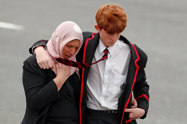 A student and a woman attend the burial ceremony of a victim of the mosque attacks, at the Memorial Park Cemetery in Christchurch, New Zealand March 21, 2019. (Photo by Edgar Su/Reuters)