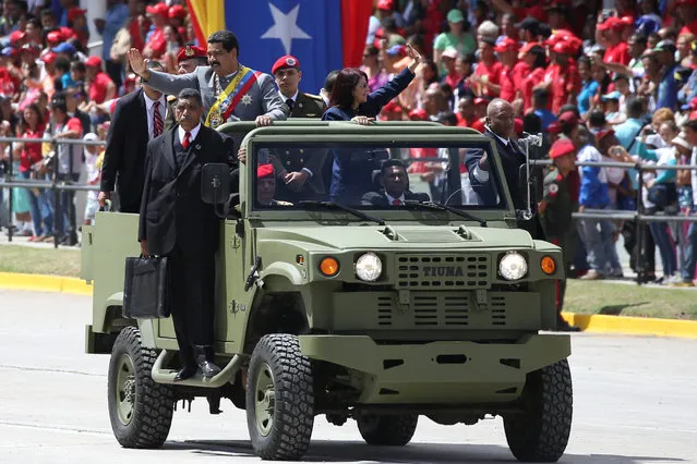 Venezuela's President Nicolas Maduro waves next to his wife Cilia Flores as they arrive to a military parade in Caracas, Venezuela February 1, 2017. (Photo by Carlos Garcia Rawlins/Reuters)