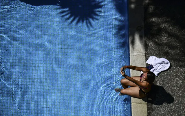 A woman takes a selfie in the pool of an hotel in Caracas on March 14, 2019. Venezuela's public employees were called to return to work Thursday after the government ended a nearly week-long hiatus caused by an unprecedented nationwide blackout that deepened widespread anger against President Nicolas Maduro. Communications Minister Jorge Rodriguez said in an address on state television Wednesday that Maduro decided the public sector would resume work on Thursday, although state schools would remain closed for an extra day. (Photo by Ronaldo Schemidt/AFP Photo)