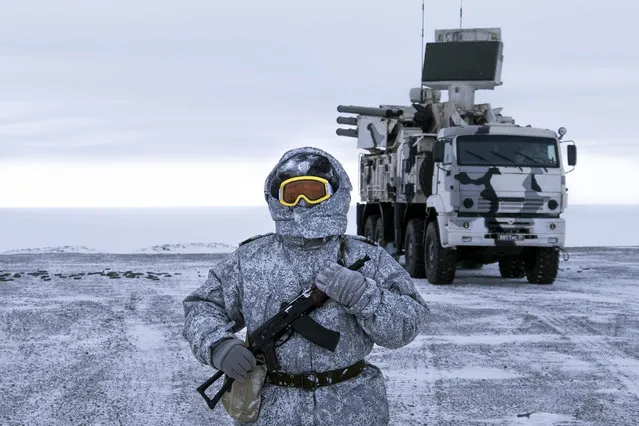 In this photo taken on Wednesday, April 3, 2019, a Russian solder stands guard as Pansyr-S1 air defense system on the Kotelny Island, part of the New Siberian Islands archipelago located between the Laptev Sea and the East Siberian Sea, Russia. Russia has made reaffirming its military presence in the Arctic the top priority amid an intensifying international rivalry over the region that is believed to hold up to one-quarter of the planet's undiscovered oil and gas. (Photo by Vladimir Isachenkov/AP Photo)