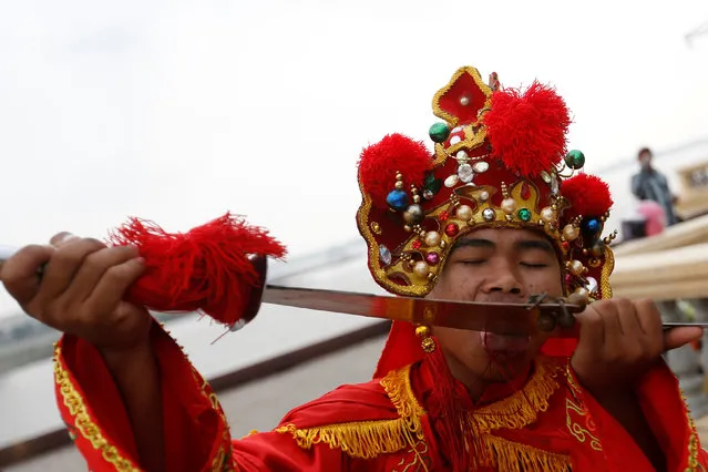 A worshipper cuts his tongue as he takes part in Hei Neak Ta, or procession of the spirits which marks the end of the celebration of the Lunar New Year for the Chinese community in Phnom Penh, Cambodia, February 10, 2017. (Photo by Samrang Pring/Reuters)