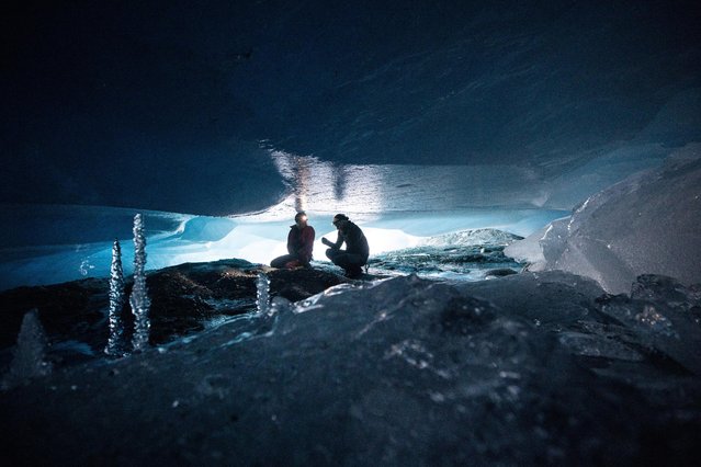 Glaciologists Andrea Fischer and Martin Stocker-Waldhuber, from the Austrian Academy of Sciences, explore a natural glacier cavity of the Jamtalferner glacier near Galtuer, Austria, October 15, 2021. Giant ice caves have appeared in glaciers accelerating the melting process faster than expected as warmer air rushes through the ice mass until it collapses. (Photo by Lisi Niesner/Reuters)