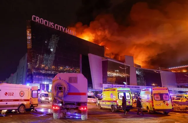 Vehicles of Russian emergency services are parked near the burning Crocus City Hall concert venue following a reported shooting incident, outside Moscow, Russia, on March 22, 2024. (Photo by Maxim Shemetov/Reuters)