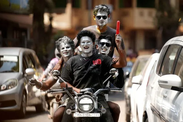 Boys with their faces painted in silver ride a motorbike during Holi celebrations in Mumbai, India, on March 25, 2024. (Photo by Hemanshi Kaman/Reuters)