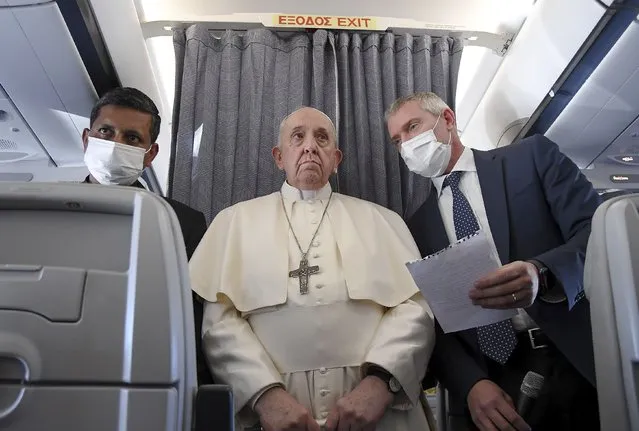 Pope Francis greets the journalists onboard the papal plane on the occasion of his five-day pastoral visit to Cyprus and Greece, Monday, December 6, 2021. Francis' five-day trip to Cyprus and Greece has been dominated by the migrant issue and Francis' call for European countries to stop building walls, stoking fears and shutting out “those in greater need who knock at our door”. (Photo by Alessandro Di Meo/Pool Photo via AP Photo)