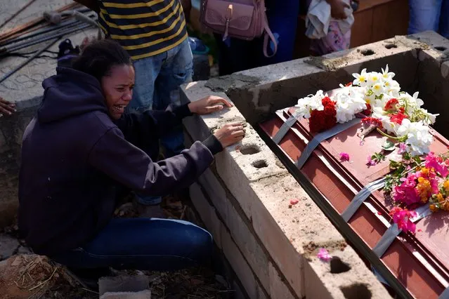 A sister of miner Santiago Mora cries as he is buried at the cemetery in La Paragua, Bolivar state, Venezuela, Thursday, February 22, 2024. The collapse of an illegally operated open-pit gold mine in central Venezuela killed at least 14 people and injured several more, state authorities said Wednesday, as some other officials reported an undetermined number of people could be trapped. (Photo by Ariana Cubillos/AP Photo)