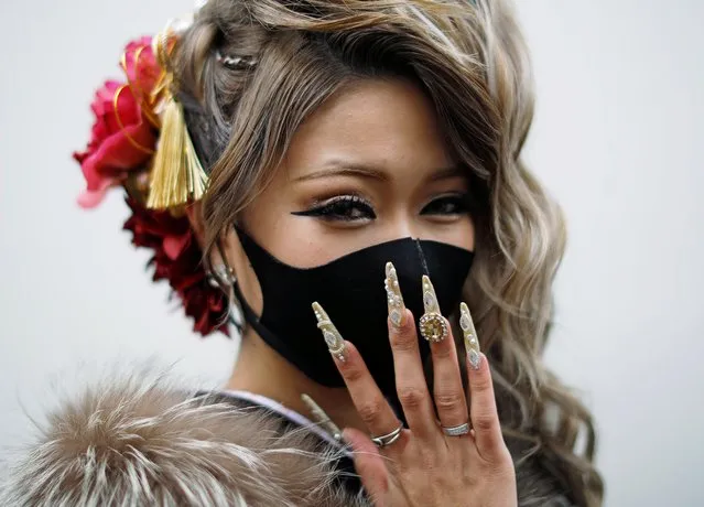 A Kimono-clad woman wearing a fashionable face mask poses for a photograph at Coming of Age Day celebration ceremony at Yokohama Arena after the government declared the second state of emergency for the capital and some prefectures, amid the coronavirus disease (COVID-19) outbreak, in Yokohama, south of Tokyo, Japan on January 11, 2021. (Photo by Issei Kato/Reuters)