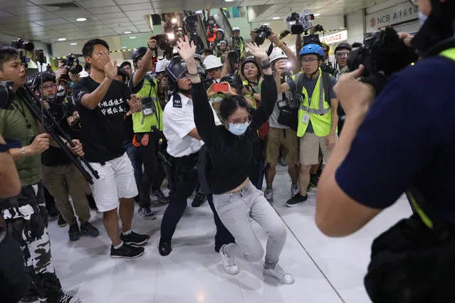 A woman is arrested by a policeman while anti-extradition bill protesters march during a rally in Shatin, Hong Kong, China, 14 July 2019. Spurred by the momentum of the anti-extradition movement, the protesters are demanding the complete withdrawal of the extradition bill, which would have allowed the transfer of fugitives to mainland China, and unconditional release of all arrested protesters among other demands. (Photo by Jerome Favre/EPA/EFE)