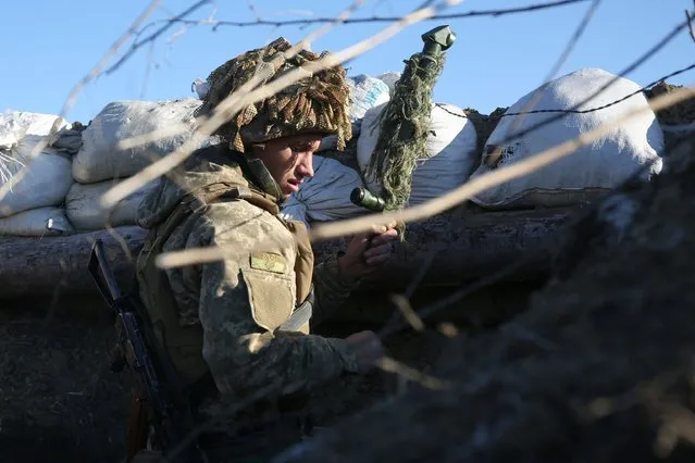 A Ukrainian Military Forces serviceman stands in a trench on the frontline with Russia-backed separatists near to Avdiivka, southeastern Ukraine, on January 8, 2022. (Photo by Anatolii Stepanov/AFP Photo)