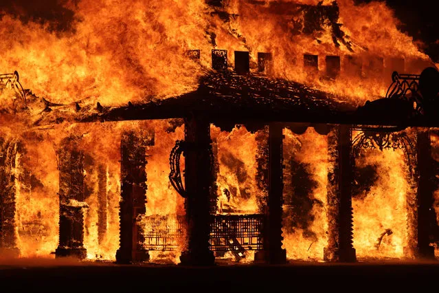 The “Temple of Time” built as a memorial to the 17 victims of a shooting at Marjory Stoneman Douglas High School is seen on fire during a ceremonial burning in Coral Springs, Fla., Sunday, May 19, 2019. The “Temple of Time” public art installation was set on fire Sunday at the ceremony hosted by the cities of Parkland and Coral Springs, where the high school's students live. (Photo by John McCall/South Florida Sun-Sentinel via AP Photo)