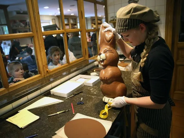 Children from a Polish tour group watch as employee Sandra Jaeckel prepares to take away a giant chocolate Easter bunny after showing it to them at Confiserie Felicitas chocolates maker on April 9, 2014 in Hornow, Germany. (Photo by Sean Gallup/Getty Images)