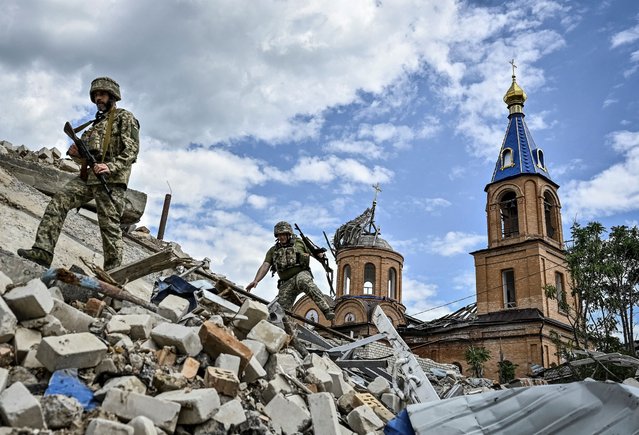 Ukrainian servicemen patrol an area heavily damaged by Russian military strikes, amid Russia's attack on Ukraine, in the town of Orikhiv in Zaporizhzhia region, Ukraine on May 20, 2024. (Photo by Reuters/Stringer)
