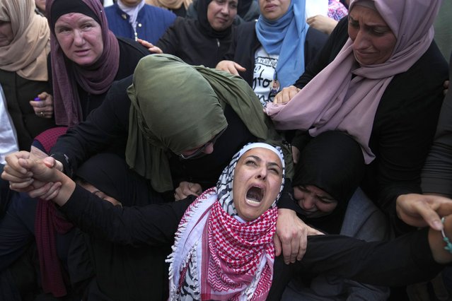 Palestinian Fayrouz Safi cries while she takes the last look at the body of her son Aysar Safi, 20, at the family house during his funeral in the West Bank refugee camp of Jalazoun, north of Ramallah Wednesday, May 15, 2024. Safi was killed during clashes with Israeli forces at the northern entrance of al-Bireh city, Palestinian ministry of health said. (Photo by Nasser Nasser/AP Photo)