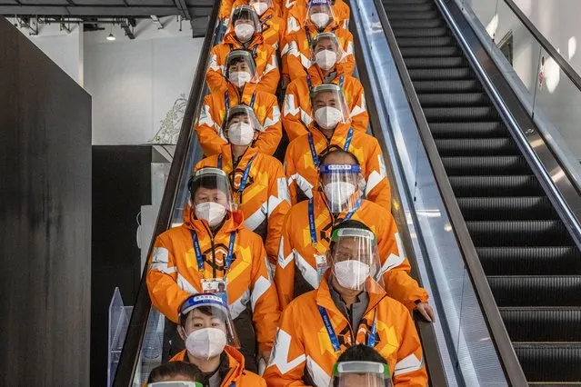 Cleaning staff wearing protective masks and face shields ride an escalator at the Olympic main media centre, which is part of the Olympic COVID-19 “bubble”, during the Beijing 2022 Olympic Games in Beijing, China, 16 February 2022. (Photo by Roman Pilipey/EPA/EFE)