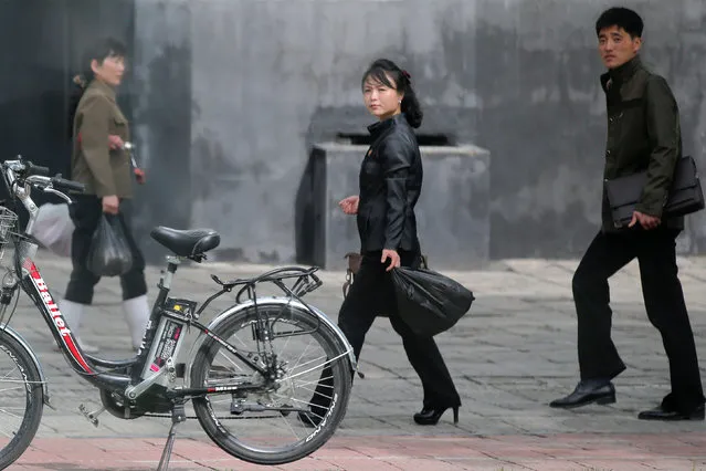 People walk past an electric bicycle in Pyongyang, North Korea May 6, 2016. (Photo by Damir Sagolj/Reuters)
