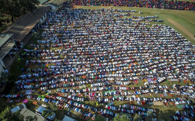 Muslim faithful take part in morning prayers to celebrate the first day of the Muslim holiday of Eid-al-Fitr, marking the end of the holy month of Ramadan, at the Eastleigh High School in Eastleigh, a suburb in Nairobi predominantly inhabited by Somali immigrants within Kenya's capital Nairobi, July 17, 2015. (Photo by Boniface Mwangi/Reuters)
